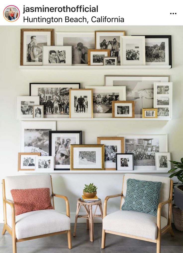 two chairs sitting next to each other in front of a wall with pictures on it