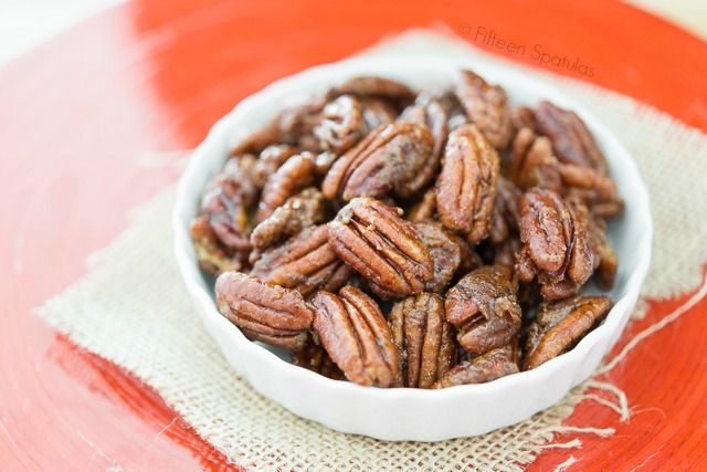 a white bowl filled with pecans sitting on top of a red and white table cloth