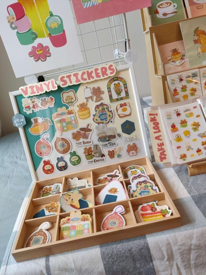 an assortment of tiny stickers in a wooden box on a table with other items