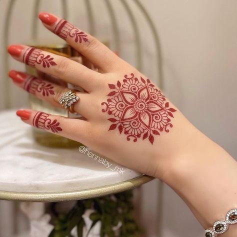 a woman's hand with henna tattoos on it