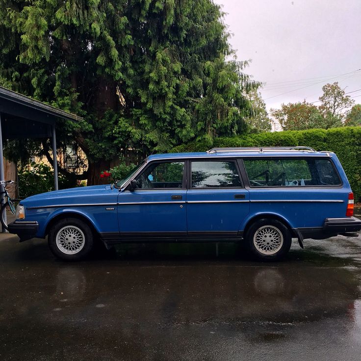 a blue station wagon parked in front of a garage