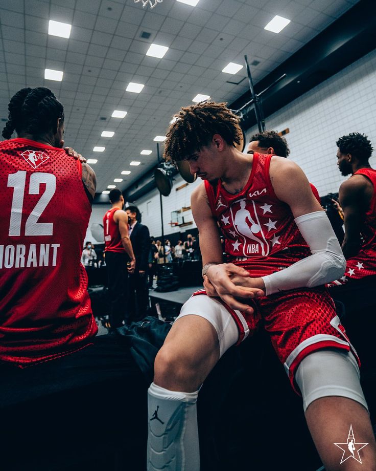 the basketball players are sitting on the bench in the locker room and waiting for their turn to play