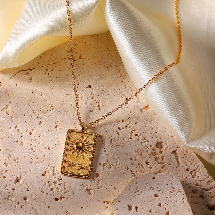 Embodying the warmth and radiance of the sun, this 18k gold-plated Sun Pendant Necklace is a symbol of vitality and energy. Its striking design adds a luminous touch to any ensemble, perfect for daily wear or special occasions. Gold Celestial Jewelry With Rectangular Pendant, Celestial Gold Jewelry With Rectangular Pendant, 14k Gold Necklaces With Sun Design, Spiritual Gold Jewelry With Sun Design, Spiritual Yellow Gold Jewelry With Sun Design, Gold Sun Design Pendant Jewelry, Gold Sun-shaped Jewelry For Everyday, Gold Plated Sun Design Necklace As Gift, Gold Plated Sun Design Necklace Gift