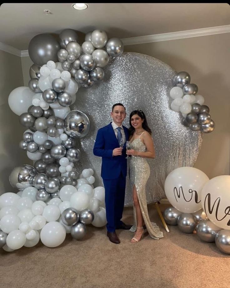 a man and woman standing in front of balloons