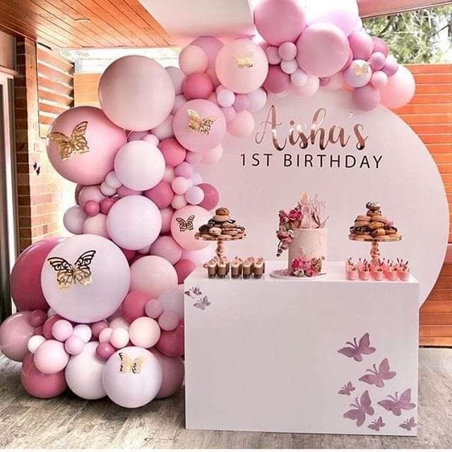 a birthday party with pink and white balloons