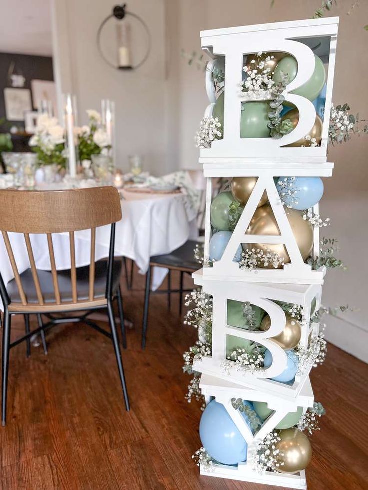 a wooden table topped with lots of white and blue decorations next to a dining room table