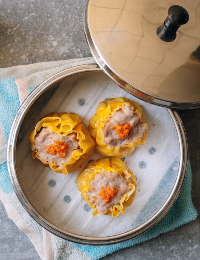 some food is sitting on a plate next to a pot and pan with the lid open