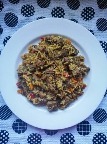 a white plate topped with rice and meat