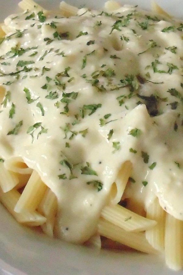 a white plate topped with pasta covered in gravy and garnished with parsley