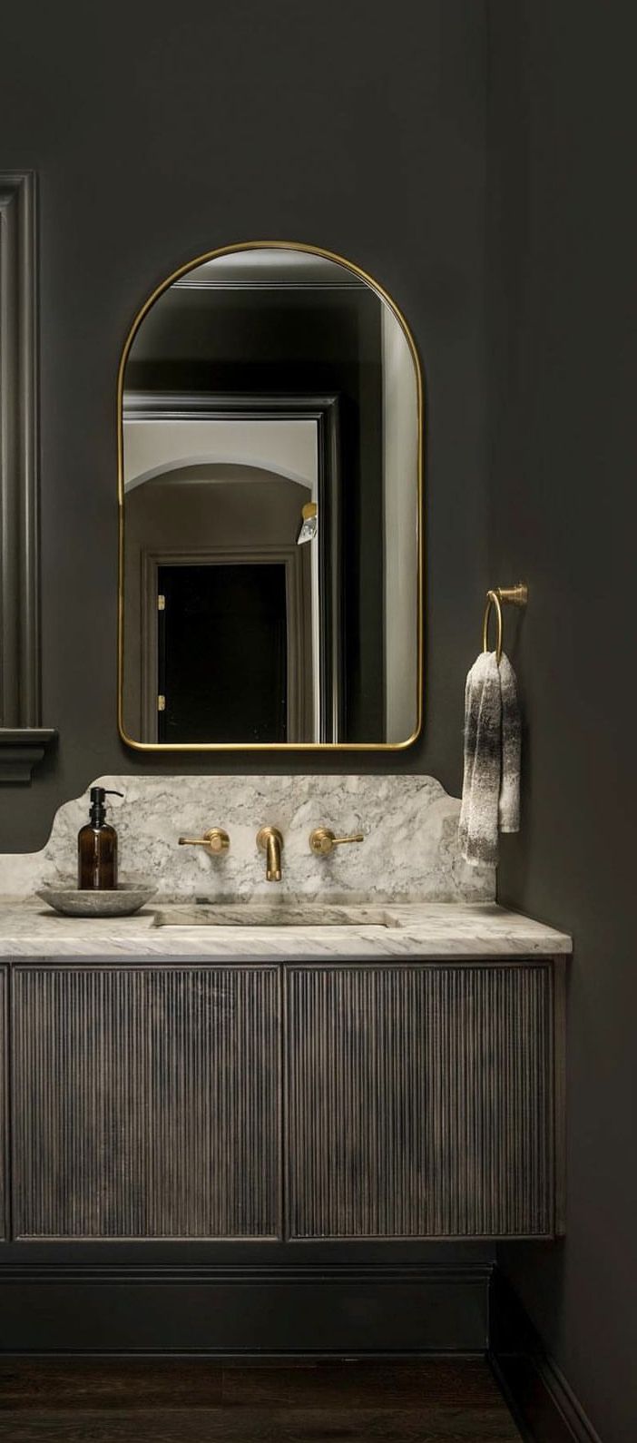 a bathroom vanity with two sinks and a large mirror in the corner, along with gold faucets