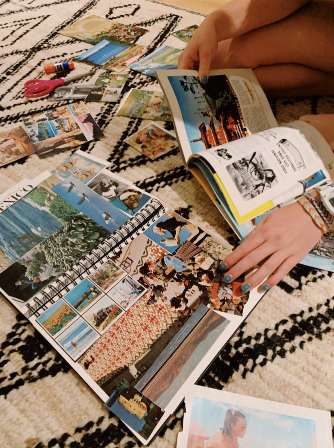 a person is laying on the floor and reading a book with pictures all over it