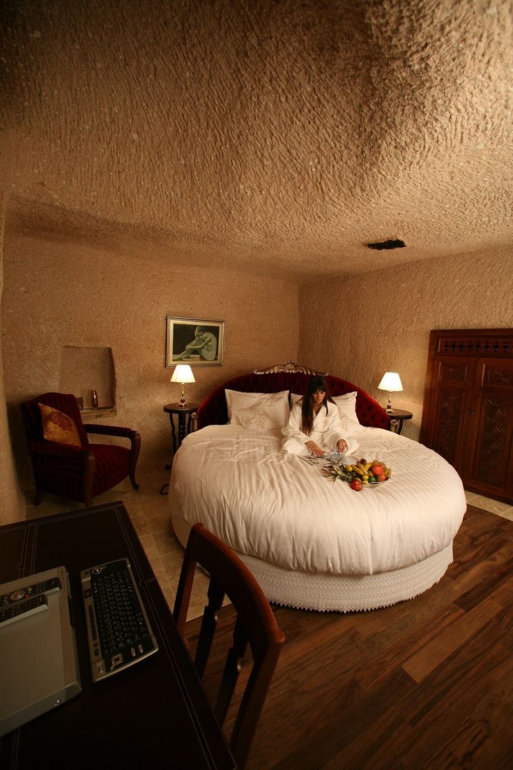 a bed sitting inside of a bedroom on top of a hard wood floor next to a desk