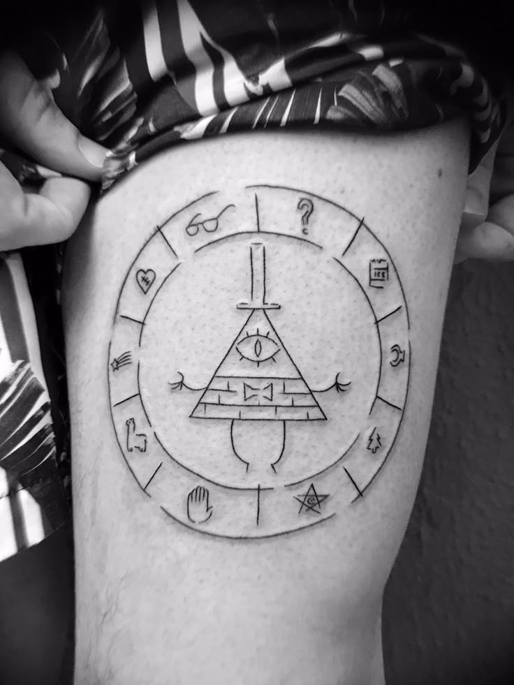 a man's thigh with an all seeing triangle tattoo on it and other symbols