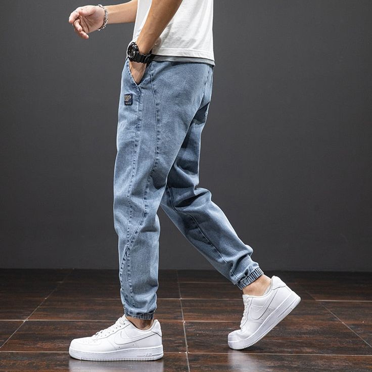 A luxurious blend of denim composes the timelessly-crafted silhouette of these jogger cargo jeans, secured with a drawstring closure and boasting a mid-waisted fit of midweight thickness. DETAILSMaterial: DenimClosure Type: DrawstringWaist Type: MidThickness: Midweight Denim Cargo Pants Men, Mid-rise Denim Blue Pants For Streetwear, Jean Cargos Men, Cargo Jeans Men, Denim Joggers Men, Blue Cargo Jeans, Jean Trousers, Harem Jeans, Streetwear Denim