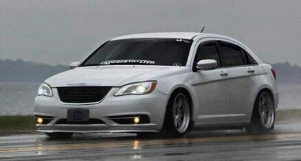 a white car driving down a wet road