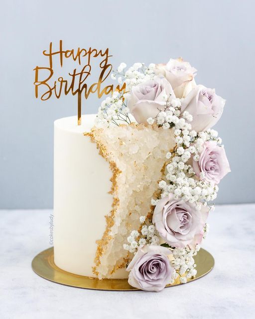 a slice of cake with flowers on it and the word happy birthday written on top