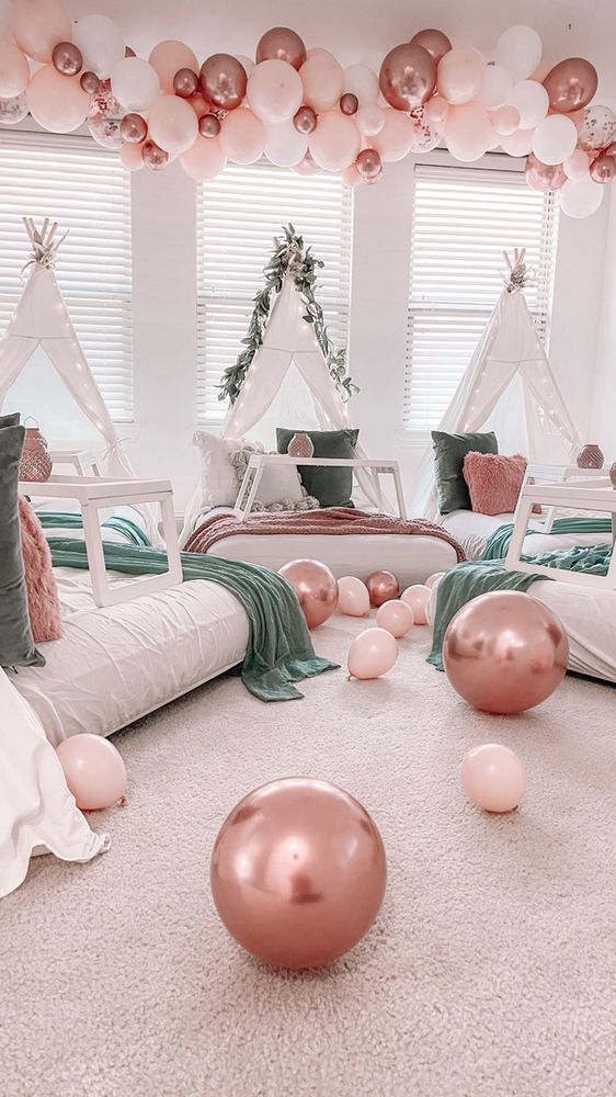 a bedroom decorated in pink and white with balloons