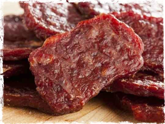 some kind of meat sitting on top of a wooden cutting board