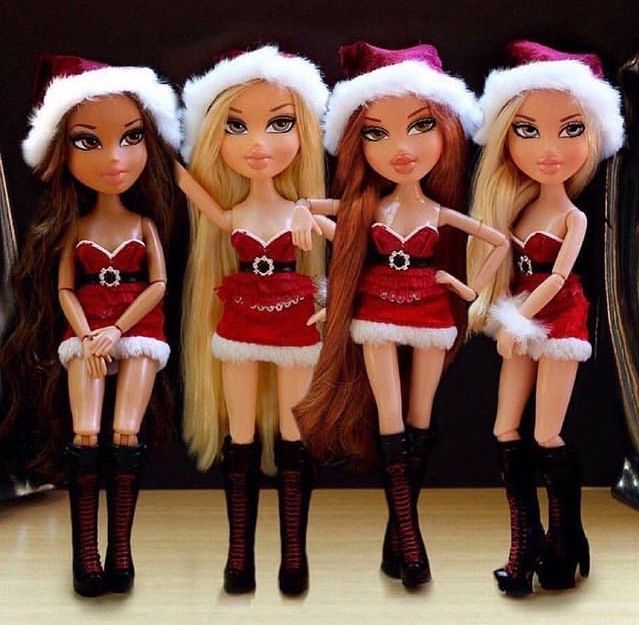 three dolls dressed up in christmas outfits and santa hats, standing next to each other