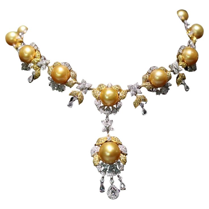 The Following Item we are offering is this Beautiful Important 18KT Gold Magnificent Rare Golden South Sea Pearl and Fancy Yellow Diamond Necklace. Necklace is comprised of 14 Beautiful Magnificent High Luster Large South Sea Golden Pearls that gives off a Golden Radiant Hue!!! Beautifully adorned with over 10CTS of Fancy Yellow, White, and Rose Cut Diamonds! Each Pearl has a Radiant Hue, High Luster with Clarity. The Diamonds are of Exquisite and Fine Quality. This Magnificent Necklace is a Rar Luxury Fine Jewelry Yellow Necklaces, Luxury Yellow Pearl Drop Jewelry, Luxury Yellow Necklaces With Diamond Accents, Luxury Yellow Hallmarked Necklaces, Luxury Exquisite Yellow Necklace, Yellow Diamond Necklace, Art Deco Pendant Necklace, South Sea Pearl Necklace, Cognac Diamonds