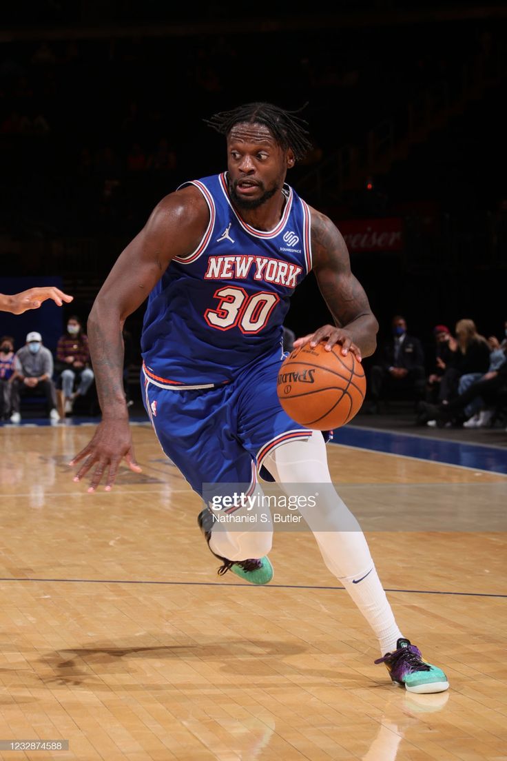 a basketball player dribbling the ball during a game against the new york nets