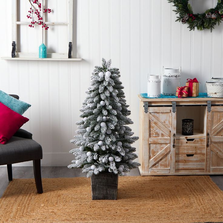 a living room with a christmas tree in the corner and other decorations on the wall