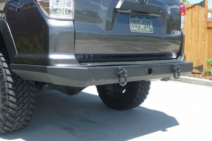 the rear end of a gray truck parked in a driveway