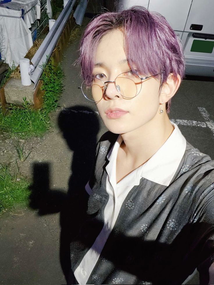 a person with purple hair and glasses on