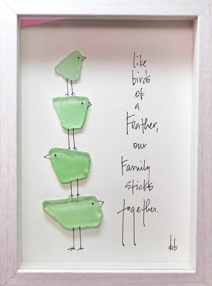 three green birds sitting on top of each other in a white frame with writing underneath