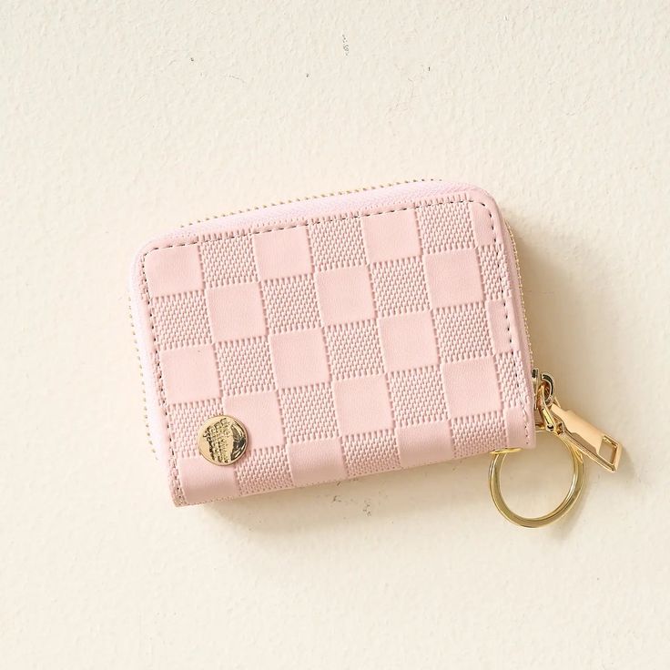 a pink wallet with a gold keychain hanging from it's front pocket