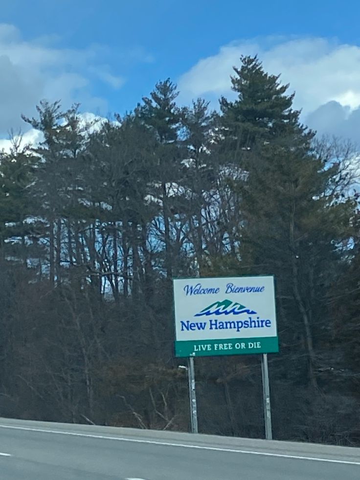 a sign on the side of a road that says welcome to new hampshire