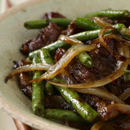 a white bowl filled with green beans and onions