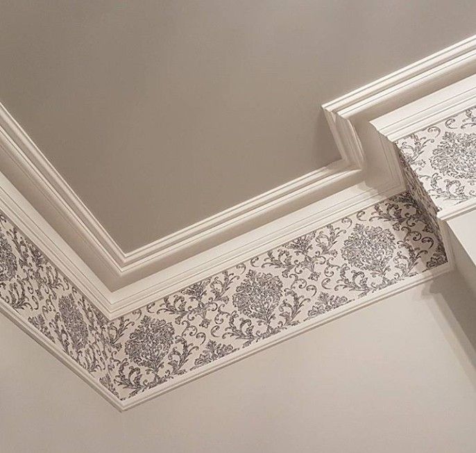 the corner of a room with an ornate pattern on the ceiling