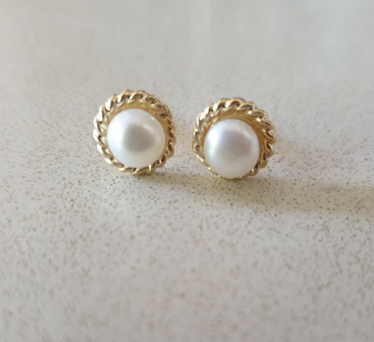 Solid gold elegant Pearl stud earrings with perfect small fresh water white pearls, designed in a vintage style. These white pearl stud earrings are beautiful and comfortable to wear day and night and can be great bridal earrings.  The can also be a perfect Bat Mitzvah gift. The 14k gold stud earrings can also be ordered without the pearls as shown in some of the photos and in the short video. Dimensions: These gold earrings' diameter is 0.5cm or 0.2 inches. Materials: The pearl studs are availa Classic Pearl White Jewelry With Pearl Buttons, Anniversary White Gold Pearl Chain Earrings, Classic Pearl Chain Bridal Earrings For Anniversary, Dainty Round 14k Gold Pearl Earrings, Classic Bridal Earrings With Pearl Chain For Anniversary, Classic 14k Gold Pearl Chain Earrings, Classic Bridal Earrings In 14k White Gold, White 14k Gold Round Bridal Earrings, Classic 14k Gold White Bridal Earrings