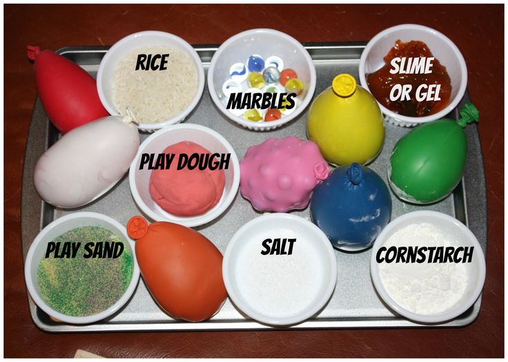 there are many different types of play doughs on the tray, including marshmallows and rice