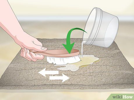 a person is using a brush to clean the sand