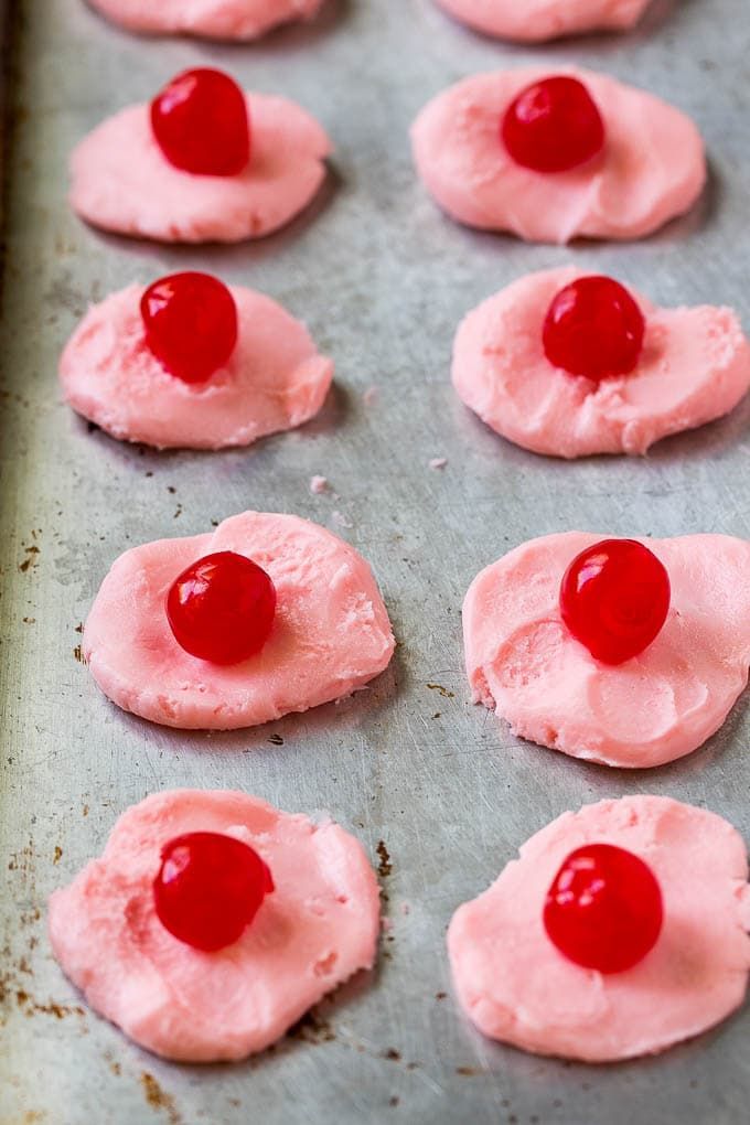 the cookies are covered in pink frosting and cherries