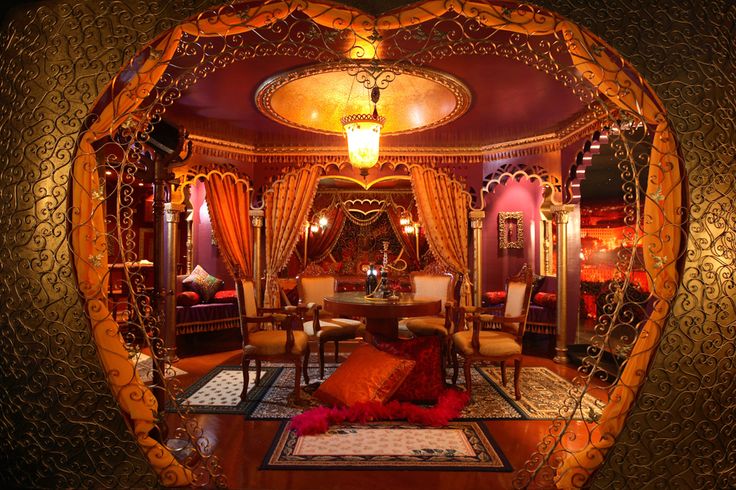 an elaborately decorated living room with gold and red accents, is seen through a fish eye lens