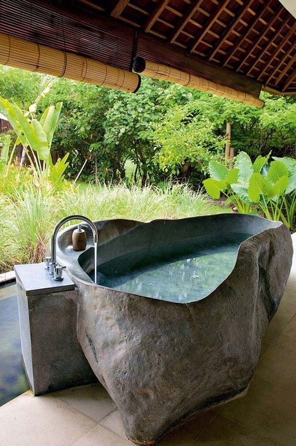 a large stone bathtub sitting on top of a patio