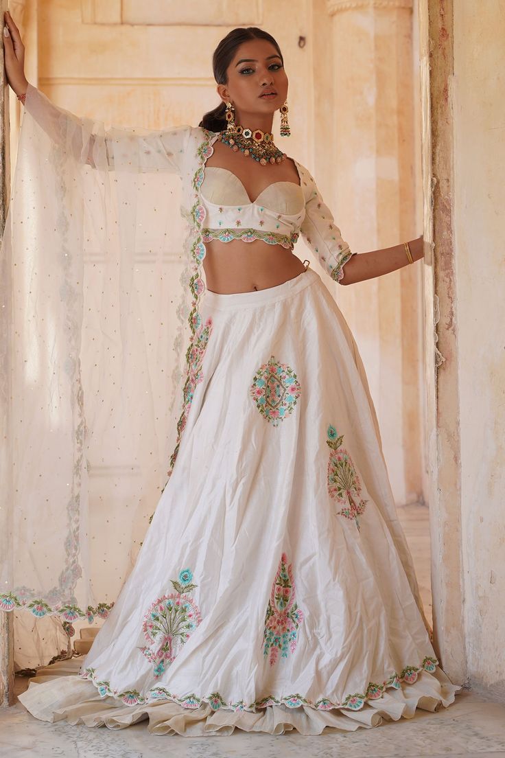 Ivory chanderi silk lehenga with ruffled border, Mughal inspired vintage pattern, multi color thread, sequin and bead embroidery. Paired with sweetheart neck blouse with all over butti pattern embroidery and dupatta with scalloped cut work border.
Components: 3
Pattern: Embroidered and Embellished
Type Of Work: Thread, Sequin and Bead Work
Neckline: Sweetheart Neck
Sleeve Type: Three Quarter Sleeves
Fabric: Chanderi Silk, Zari, Lining: Cotton Silk
Color: Ivory
Other Details: 
Scalloped cut work Hem Blouse, Pattern Embroidery, Silk Lehenga, Fashion App, Sweetheart Neck, Bead Embroidery, Cut Work, Embroidered Silk, Color Ivory