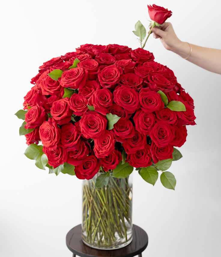 a vase filled with red roses on top of a table