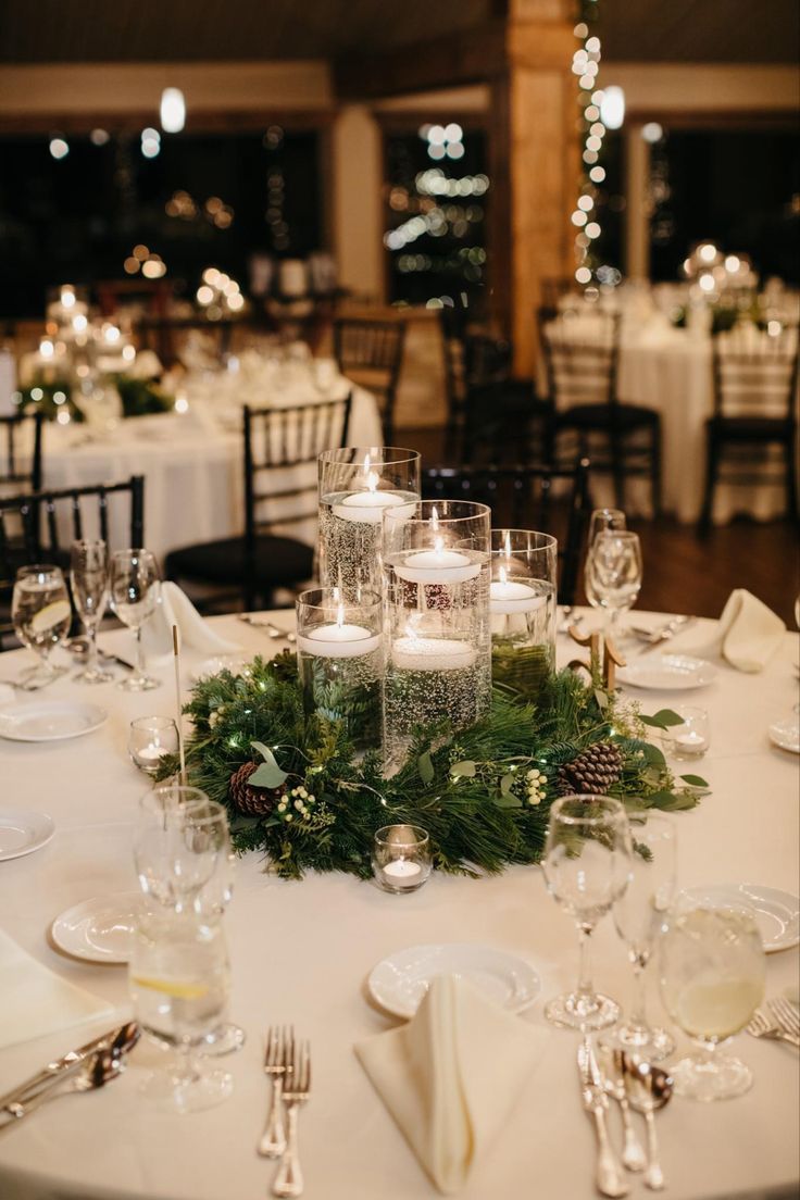 the table is set with candles and greenery