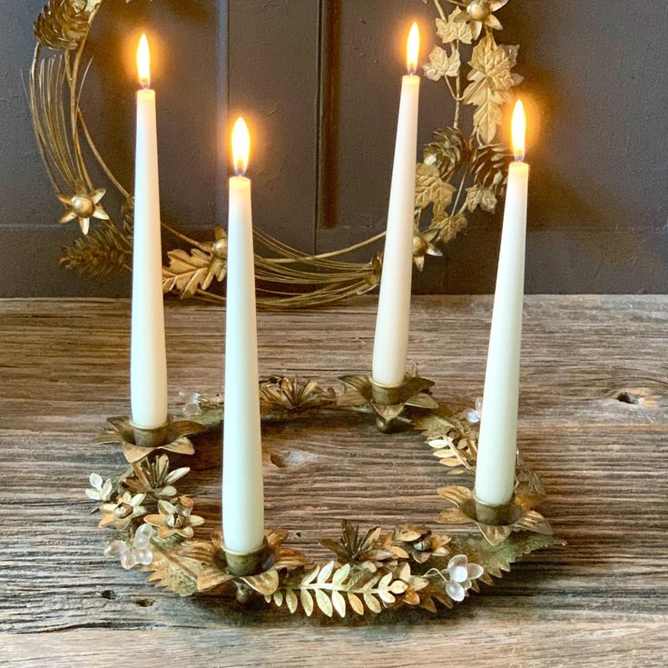 four candles are arranged in the shape of a wreath