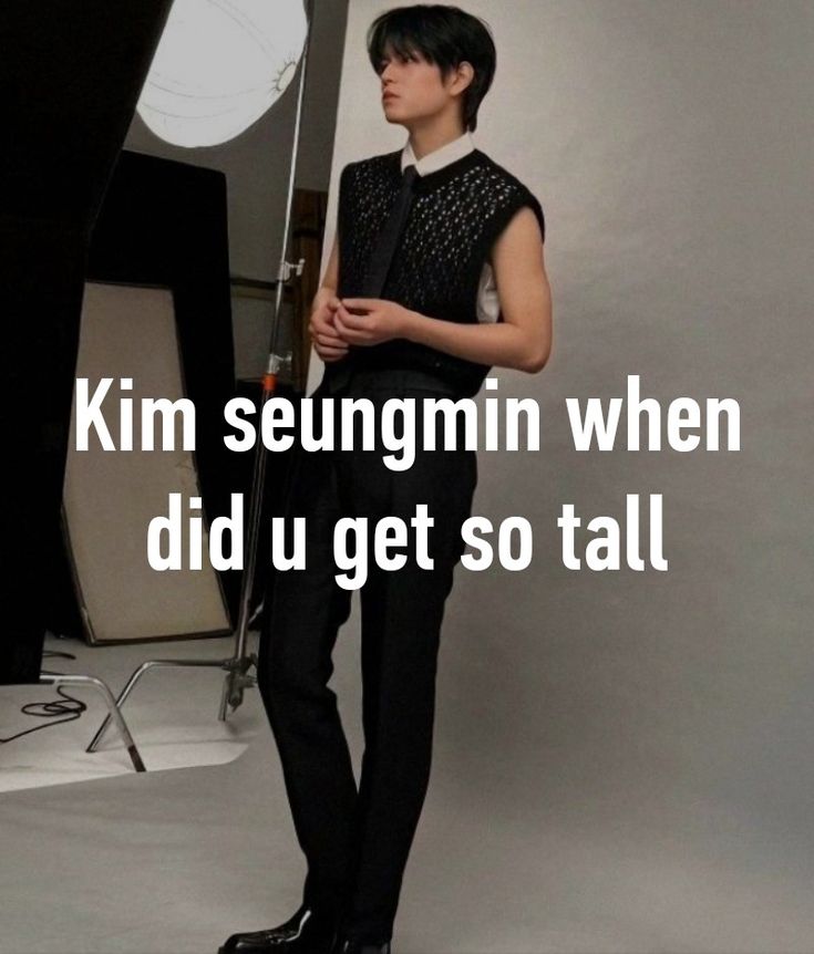 a man standing in front of a camera with the words kim seungmin when did u get so tall?