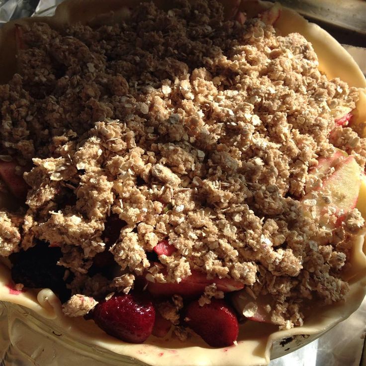 a bowl filled with crumbs and fruit on top of a table