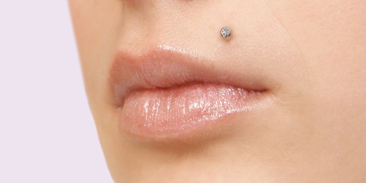 a woman's nose with a tiny diamond on it and the tip of her lip