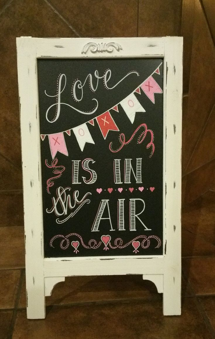 a chalkboard sign that says love is in the air