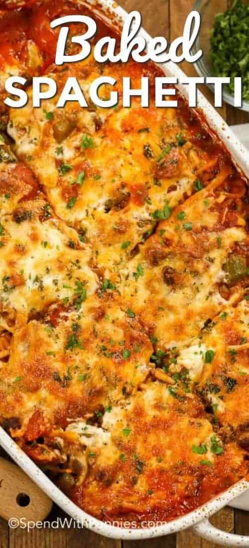 baked spaghetti casserole in a white baking dish with parsley on the side