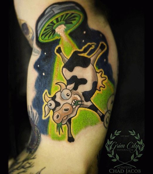 a man with a tattoo on his arm has a cow in the middle of it