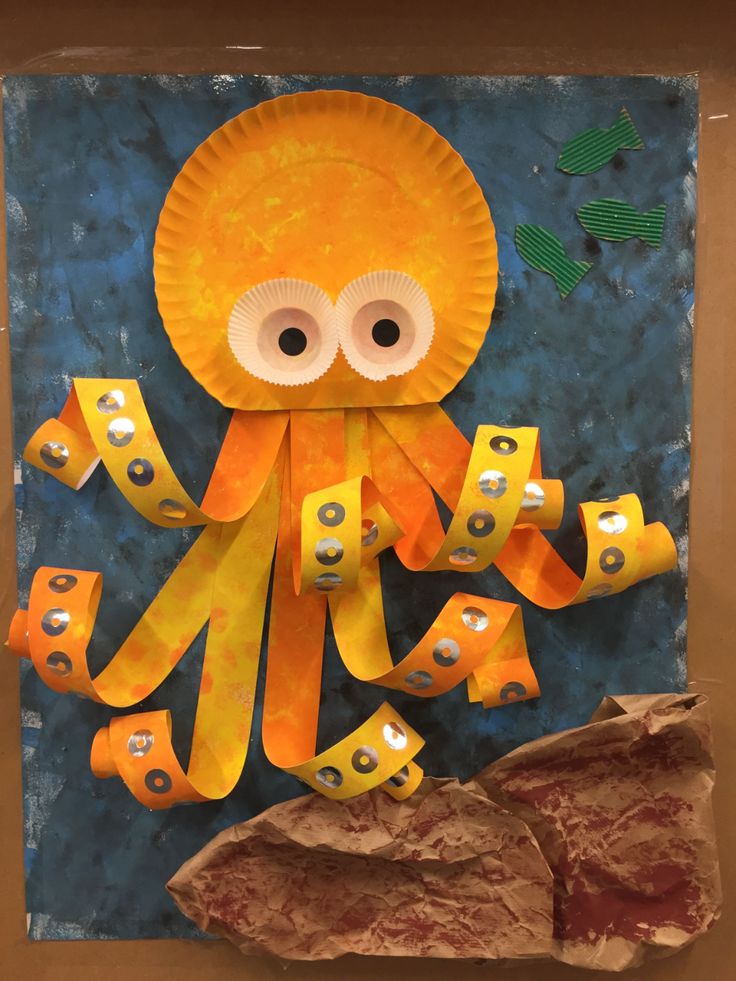 an octopus made out of construction paper with eyes on it's head and hands